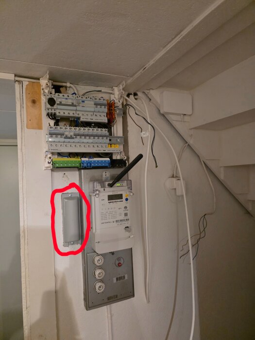 Elcentral med elmätare och markerad antenn; klippt kabel synlig.