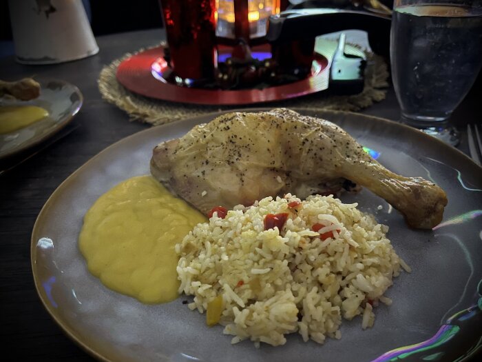 Ugnsgrillad kyckling med stekt ris innehållande paprika och lök, och currysås på en tallrik.