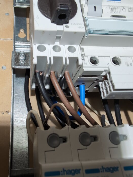 Elcentral med bruna, blå och svarta kablar. Vissa ledare verkar dåligt skalade och inkonsekventa färgval.