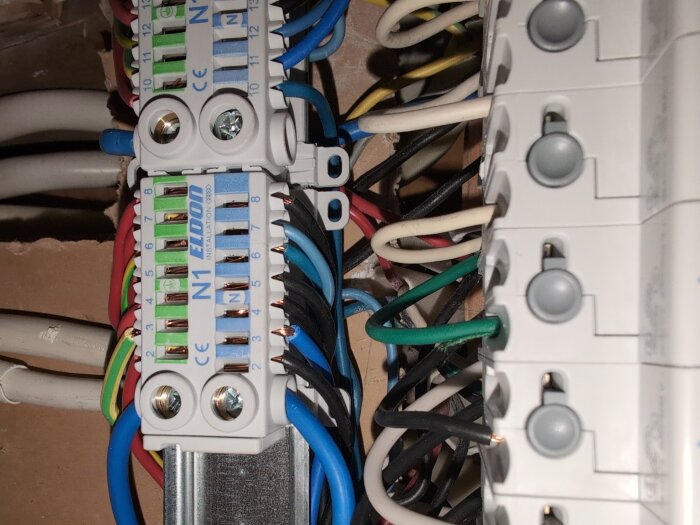 Elcentral med olika kablar exponerade, blandade färger på ledningar och okonsekvent isolering, kopplingsplint med texten "ELDON N1".