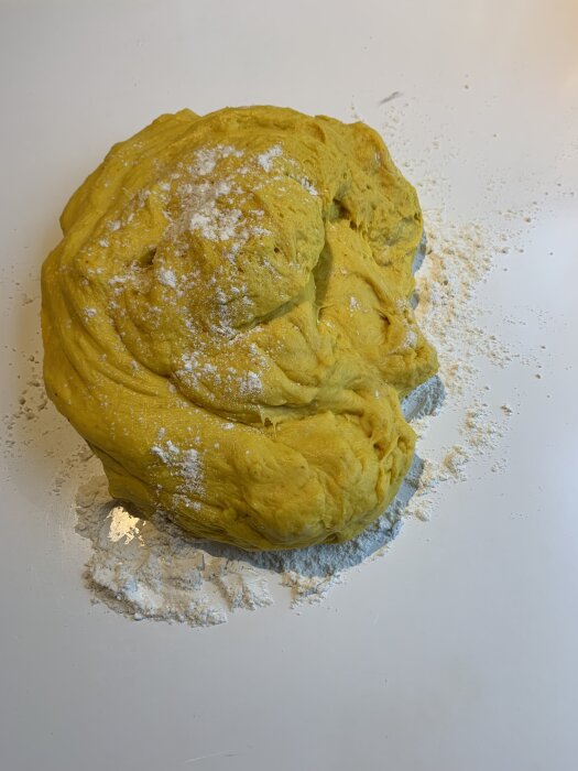 Deg till lussebullar med mjöl på en köksbänk.