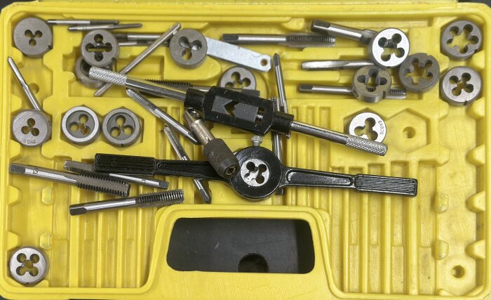 Gäng- och borrsats i en gul verktygslåda med diverse delar och bits.