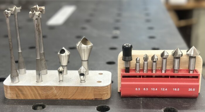 Två verktygssatser med försänkare och borr-/gängsatser i olika storlekar, monterade på trä- och metallställ.