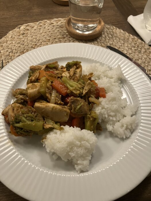 Rester av ugnskyckling med wokade grönsaker och ris på en tallrik. Ingefära, vitlökspasta och stir fry sås som smaksättning.