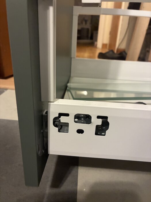 Närbild av en lådfront med monteringsbeslag i ett kök.