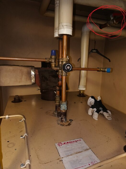 Inringad ventil på vattensystem i ett tekniskt skåp, möjliga vattenkranar.