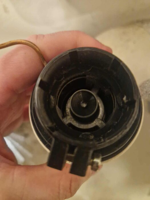 Närbild av en hand som håller i en shuntsystems del, sedd framifrån.