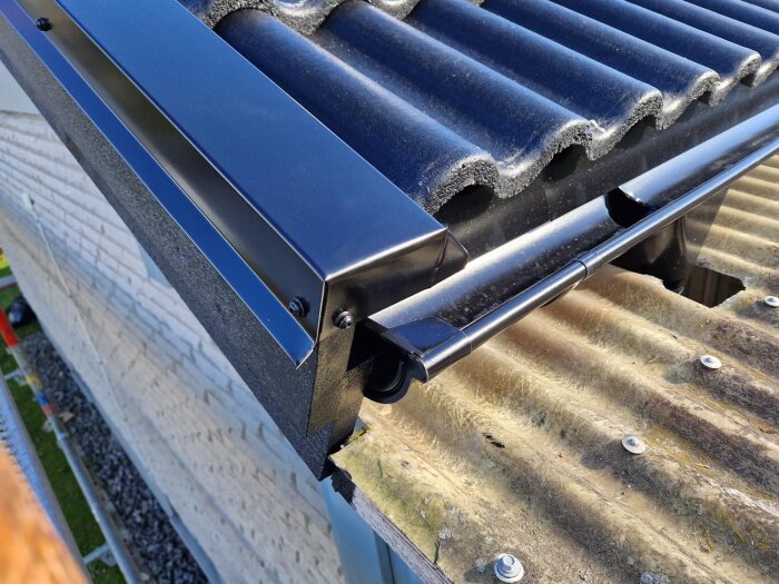 Takdetalj med nyinstallerad hängränna och takplattor, närbild.