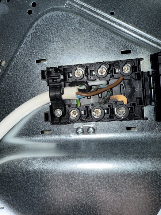 Elektrisk anslutning bakom spis med bränd kabel och koppling, potentiell orsak till funktionsstörning enligt inlägg.