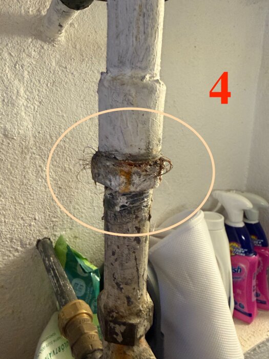Rostigt galvaniserat rör nummer 4 med synliga skarvar och trasigt isoleringsmaterial, i behov av renovering i en tvättstuga.