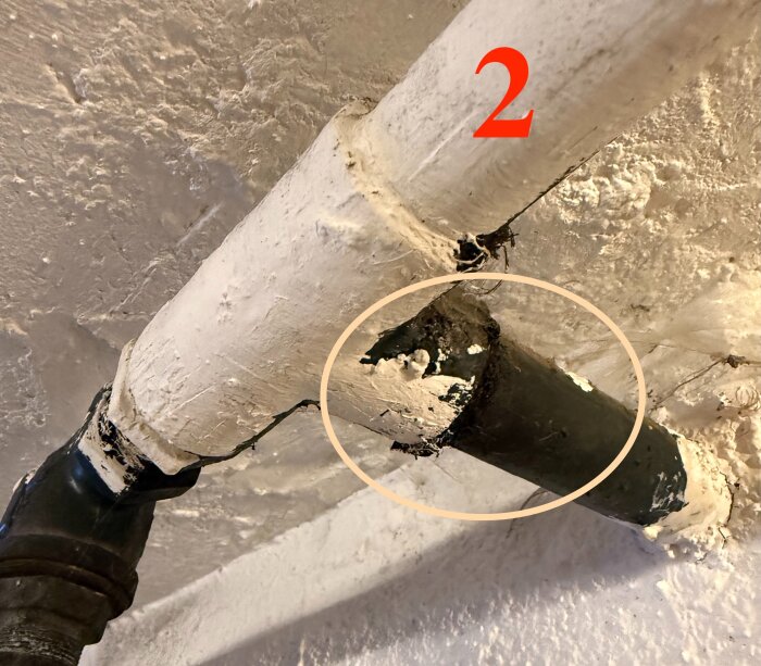 Galvrör i källartak med nummer "2", vitmålad yta och sliten insida. Tänkt att ersättas av nyligen inflyttad husägare för bättre vattenflöde.