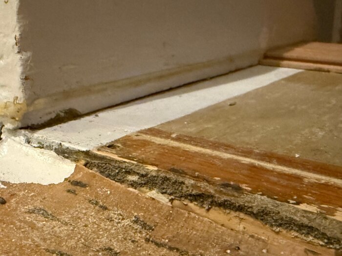 Närbild på trappa med synlig höjdskillnad mellan trappsteg och intilliggande yta där golv har avlägsnats, avslöjande olika material och nivåer.