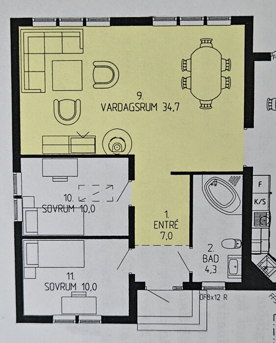 Planritning som visar en gulmarkerad yta för vardagsrum, med markerat entréområde och angränsande sovrum och badrum.