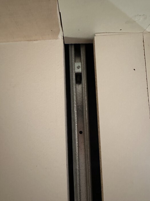 Glapp vid skjutdörr med synlig mellanrum mellan vägg och dörrkarm, indikerar plats för luftläckage i ett hem.