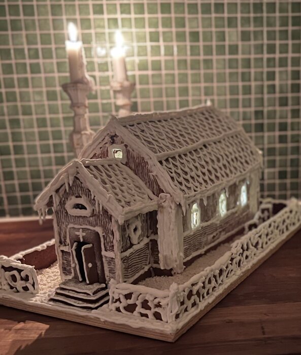 Pepparkakshus föreställande Dalarö kyrka, dekorerat med vit kristyr och med små fönster som lyser upp inifrån.
