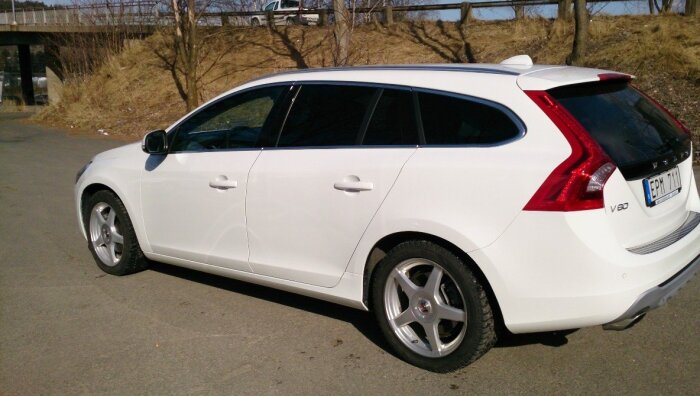 Vit Volvo V60 kombi parkerad utomhus, bakifrån sedd.