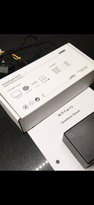 Förpackning till Autoplugin RCP Heater Remote Control och installationsmanual på ett bord.