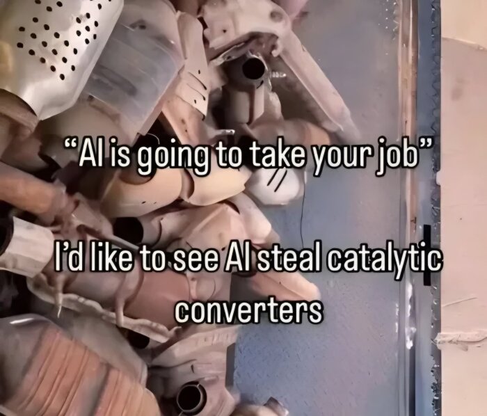 Catalytic converters in a heap with text: "AI is going to take your job. I'd like to see AI steal catalytic converters.