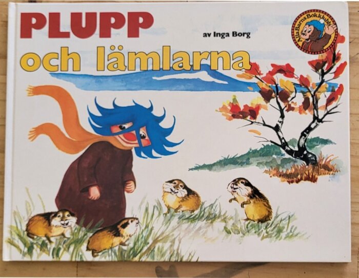 Bokomslag för "Plupp och lämlarna" av Inga Borg, visar Plupp med blått hår och halsduk vid färgglada träd, omgiven av lämlar.