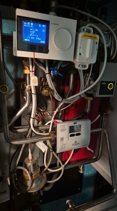 Värmeregleringssystem med kablar, rör och centralenhet från Danfoss. Display och manöverventil synliga.