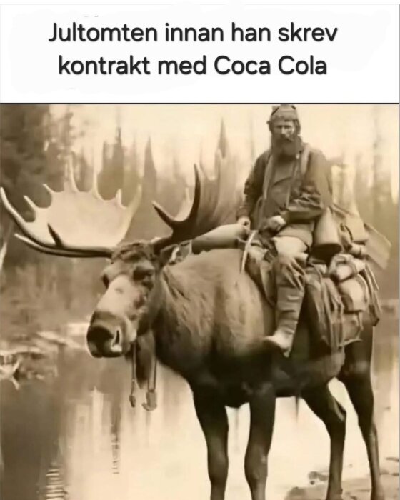 Man klädd som tomte rider på en älg i skogsmiljö, med texten "Jultomten innan han skrev kontrakt med Coca Cola" ovanför.