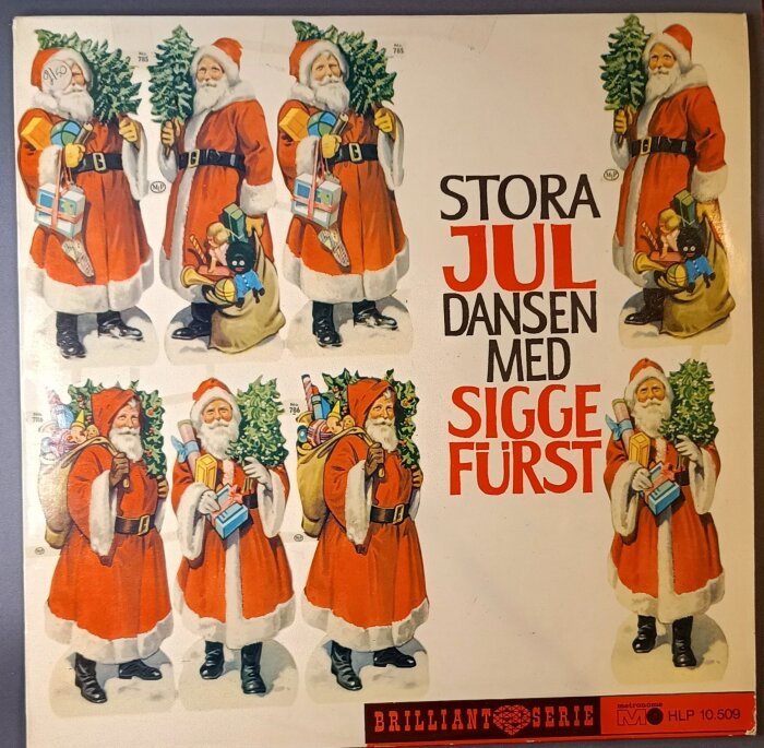 Omslag av julskiva "Stora Juldansen med Sigge Fürst" med illustrationer av jultomtar med julgranar och gåvor i säckar.