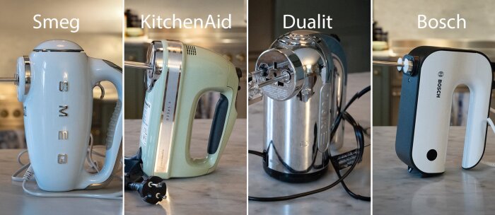Fyra elvispar: Smeg, KitchenAid, Dualit och Bosch, uppställda på en bänkskiva.
