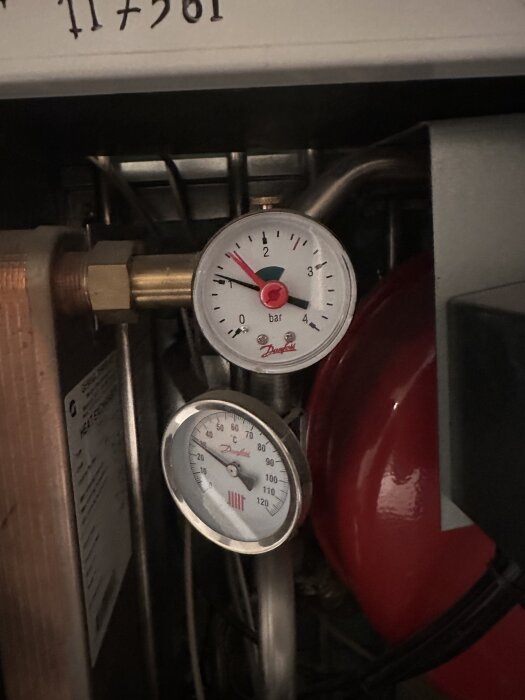 Manometer och termometer på en fjärrvärmepump, visar tryck och temperatur.