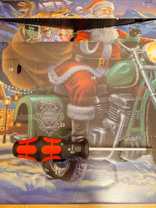 Leksaksjultomte på motorcykel på en adventskalender, med en skruvmejsel ovanpå.