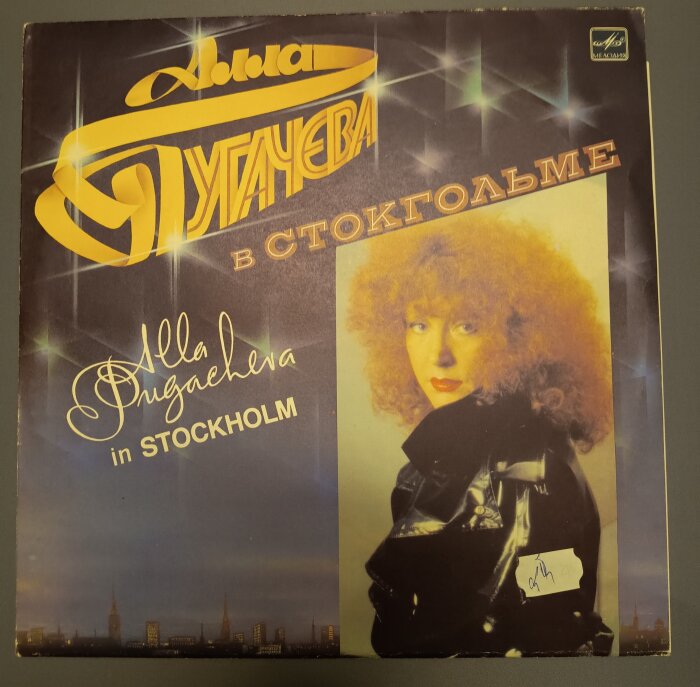 Skivomslag för "Alla Pugacheva i Stockholm" med färgbild av artisten i svart klädsel, text på ryska och engelska, prisetikett synlig.