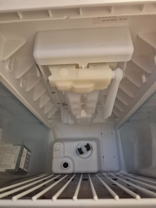 Magnetventil i frysen med snurrbar del och skruv; överst en ismaskin.