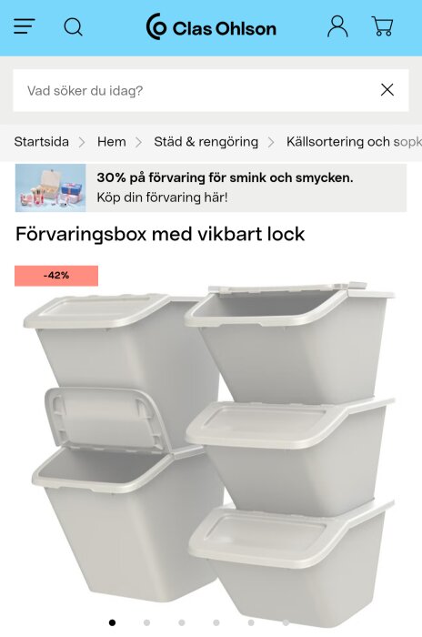Fyra vita förvaringsboxar med vikbart lock staplade på varandra, en med öppet lock. Rabatt på 42% visas.