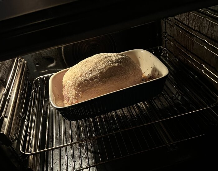 Julskinka med griljering i en ugnsform i ugnen, redo att serveras till frukost.