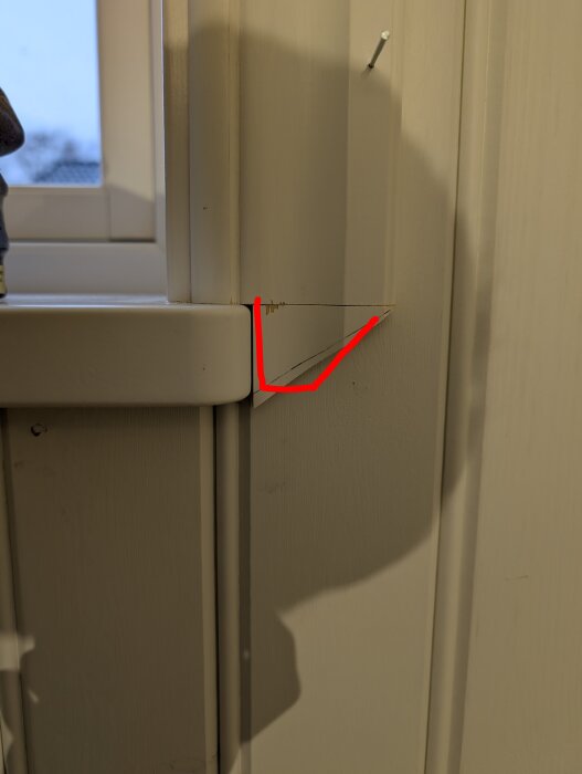 Träbit monterad vid fönsterkant med röd linje och skugga; diskuteras som provisorisk lösning för byggprojekt.
