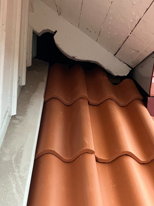 Rött taktegel under vitmålad träkonstruktion med synliga detaljer och vinklar.