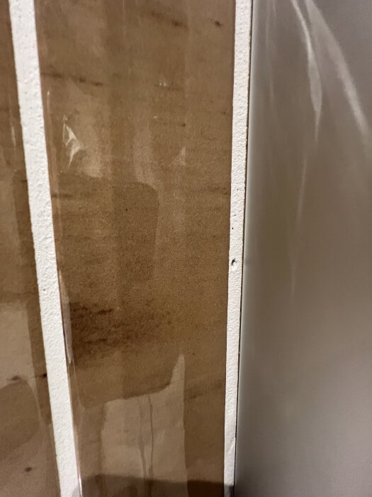 Bild av en duschväggsinstallation med exponerade rör och vattenmärken; visar brist på korrekt montering och finish i badrum.