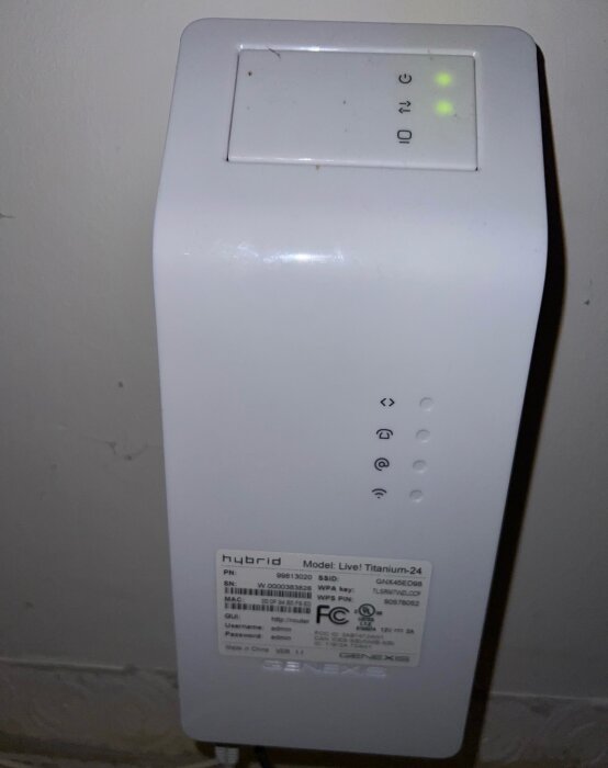 En vit Hybrid-router med modellnamn "Live! Titanium-24" visas, med gröna lampor och etiketterade knappar på framsidan.