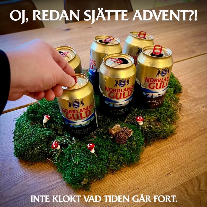 Sex burkar öl på en mossklädd yta med små dekorativa svampar och kottar, en hand når efter en burk. Texter på bilden refererar till "sjätte advent".