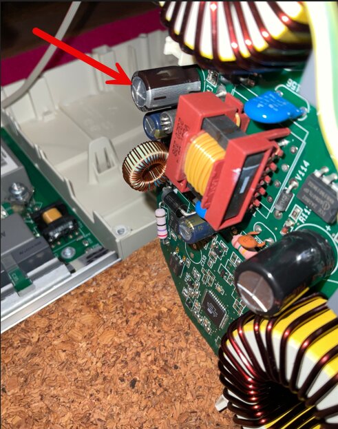 Närbild på kretskortet i en Miele induktionshäll med en kondensator markerad med pil.