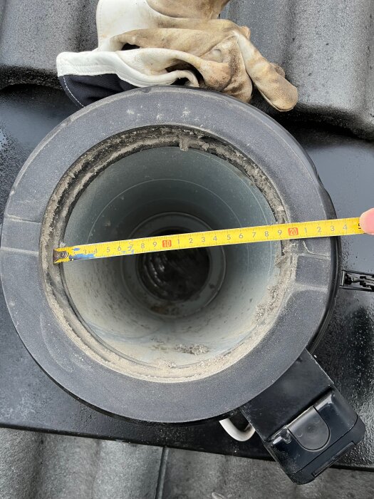 Närbild på rörgenomföring med en innerdiameter på 200 mm, mätt med ett måttband.