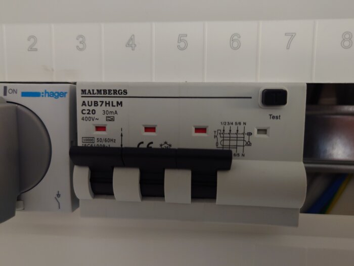 Malmbergs AUB7HLM automatsäkring, C20 30mA 400V, med märkningar och testknapp, installerad i en elcentral.