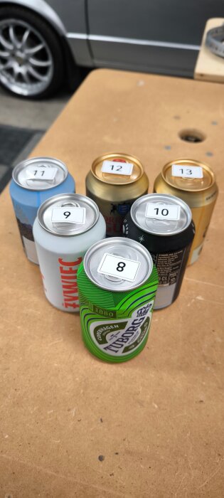 Sex numrerade burkar står på ett bord, varje burk har en etikett med ett nummer från 8 till 13.