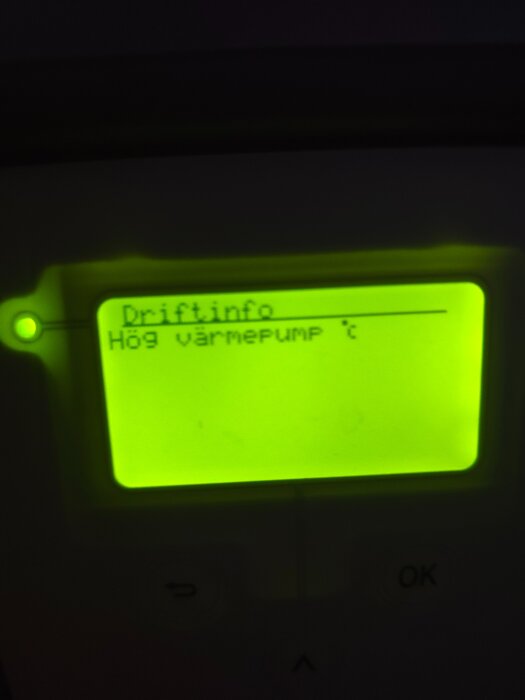 Display med texten "Driftinfo: Hög värmepump" på en elektronisk panel med grön belysning.