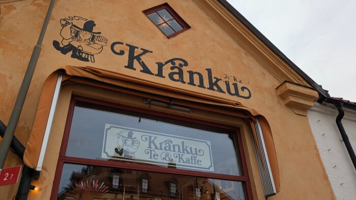 Fasaden av Kränku te- och kaffebutik med skylt och illustration av en man med kaffekopp.