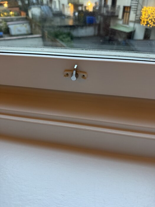 Fönsterspärr monterad längst ner på ett fönster. Spärren ska tryckas för att öppna mer än för vädring, används som vädrings- och barnsäkerhetsspärr.