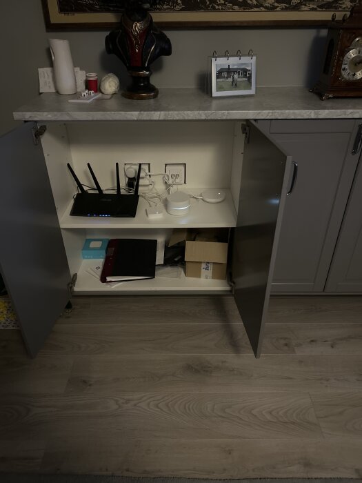Öppet skåp med Asus TUF AX4200 WiFi 6 router och kringutrustning, arrangerat i ett Ikea Metod-skåp med flera hyllor.