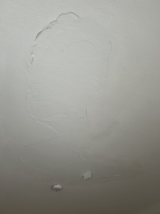 Sprucket och flagande tak i vardagsrum, eventuell limfärg. Risk för fukt, beläget nära yttervägg och fönster. Misstanke om mögel.