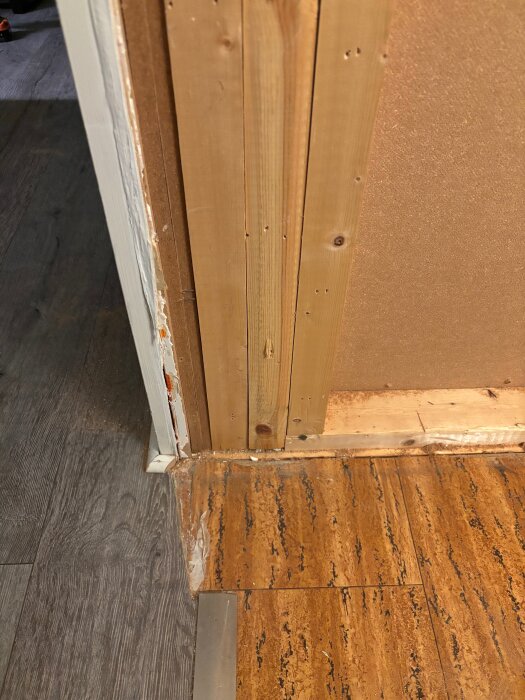 Regelstruktur i väggöppning med synliga träreglar och laminatgolv, från en hall i ett kedjehus.