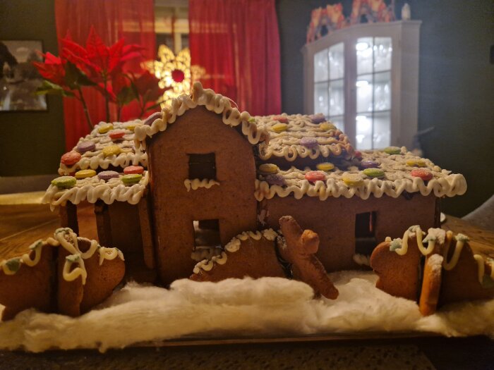 Pepparkakshus med dekorationer av glasyr och godis, föreställande en modell av ett hem.