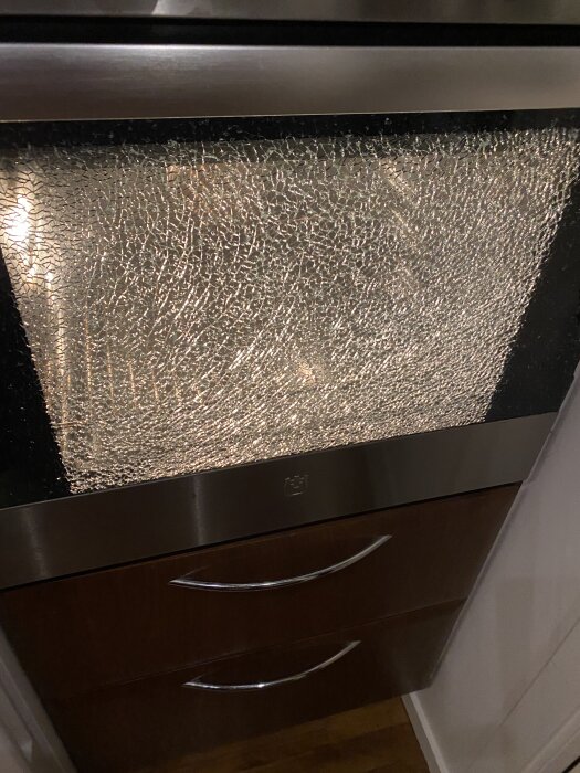 Explosionen av ugnsglas på en gammal Electrolux, med sprucket glas sett i närbild. Golvet fullt av glassplitter.